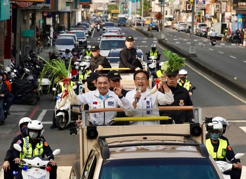 國民黨總統參選人侯友宜（宣傳車上前左）14日下午與黨籍高雄市立委參選人曹桓榮（車上前右）在岡山地區以車隊掃街方式展開拜票行程，2人高舉民眾...